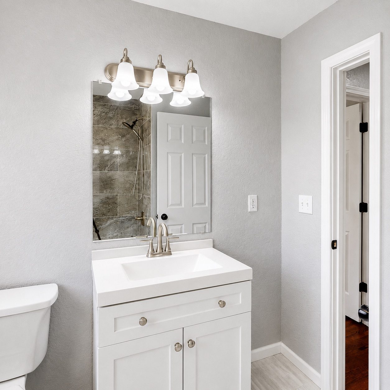 A fitted bathroom with vanity unit and tiled shower enclosure