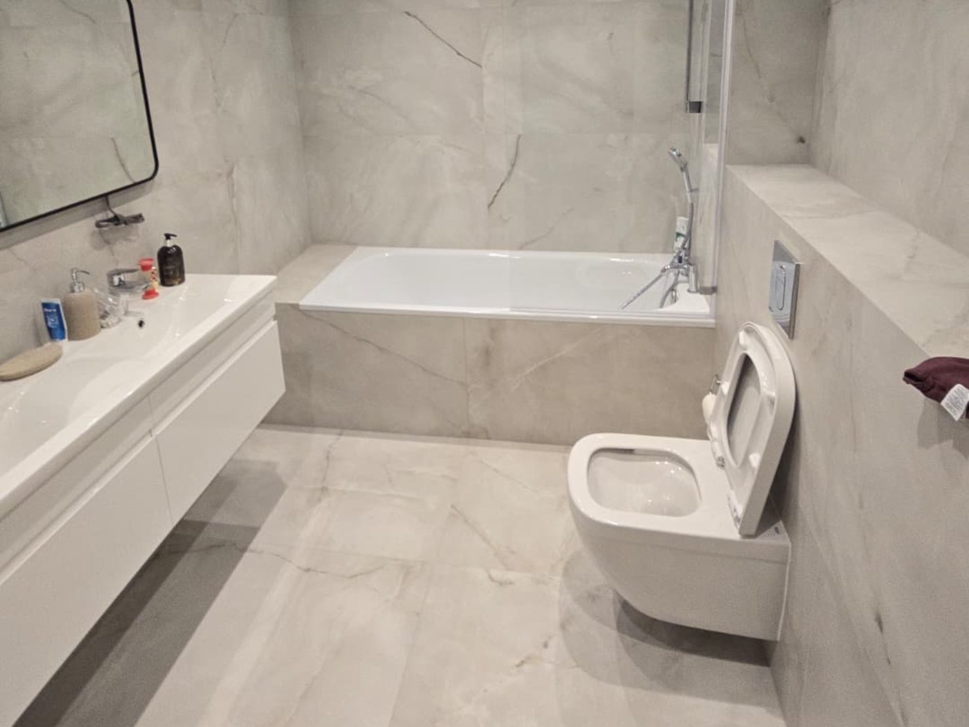 A bathroom fitted by GS Renovation with a panelled bath and a floating double vanity