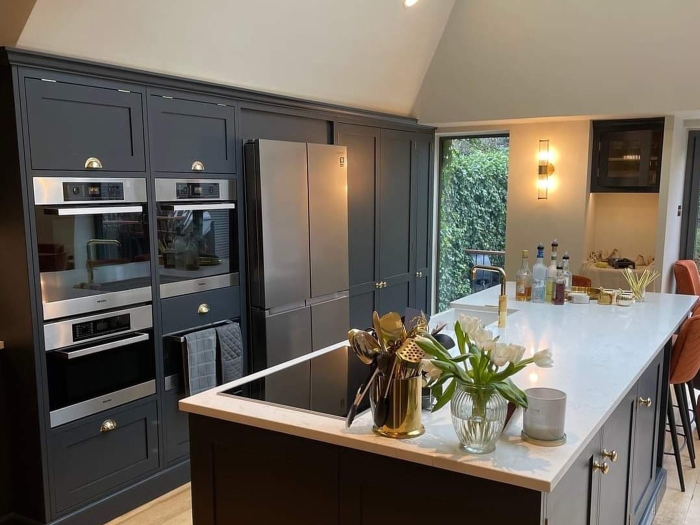 A navy shaker kitchen installed by GS Renovation beneath a roof lantern